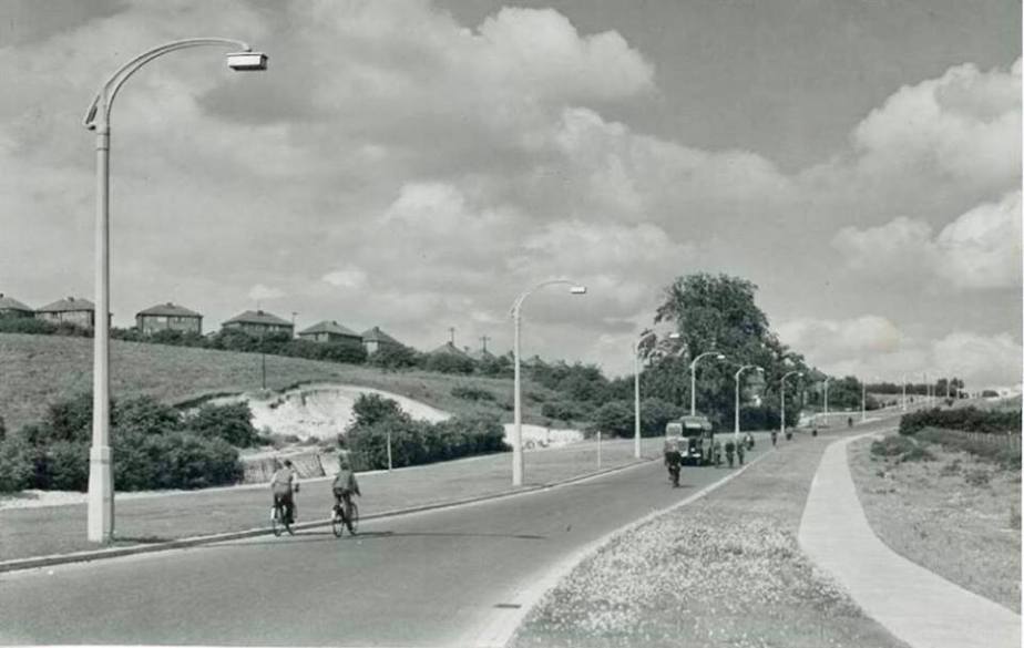 c1950. Eaton Green Rd. Them two cyclists passing roughly where the Wyvern pub will be built later. Looks like Hollybush Rd up on the left.jpg